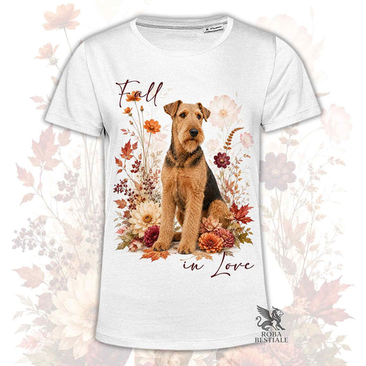 T-shirt bianca stampata con un Airedale Terrier seduto in mezzo a fiori e foglie autunnali. Grafica originale Roba Bestiale, collezione Fall