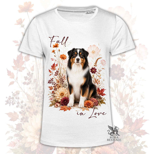 T-shirt bianca stampata con un Australian Shepherd seduto in mezzo a fiori e foglie autunnali. Grafica originale Roba Bestiale, collezione Fall in Love