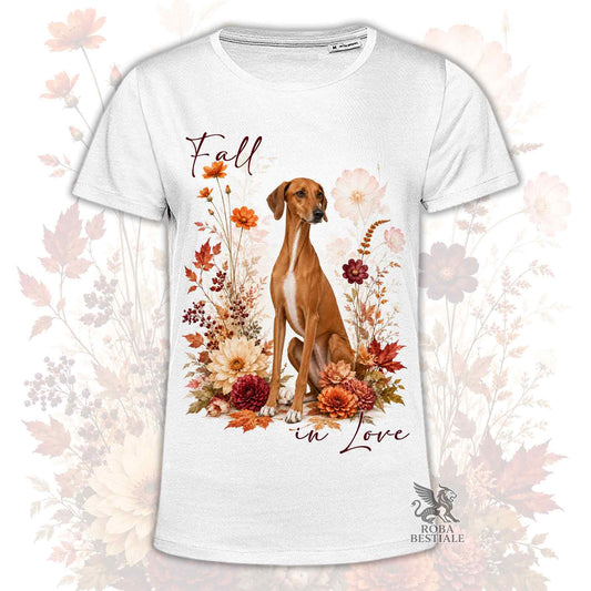 T-shirt bianca stampata con un Azawakh seduto in mezzo a fiori e foglie autunnali. Grafica originale Roba Bestiale, collezione Fall in Love