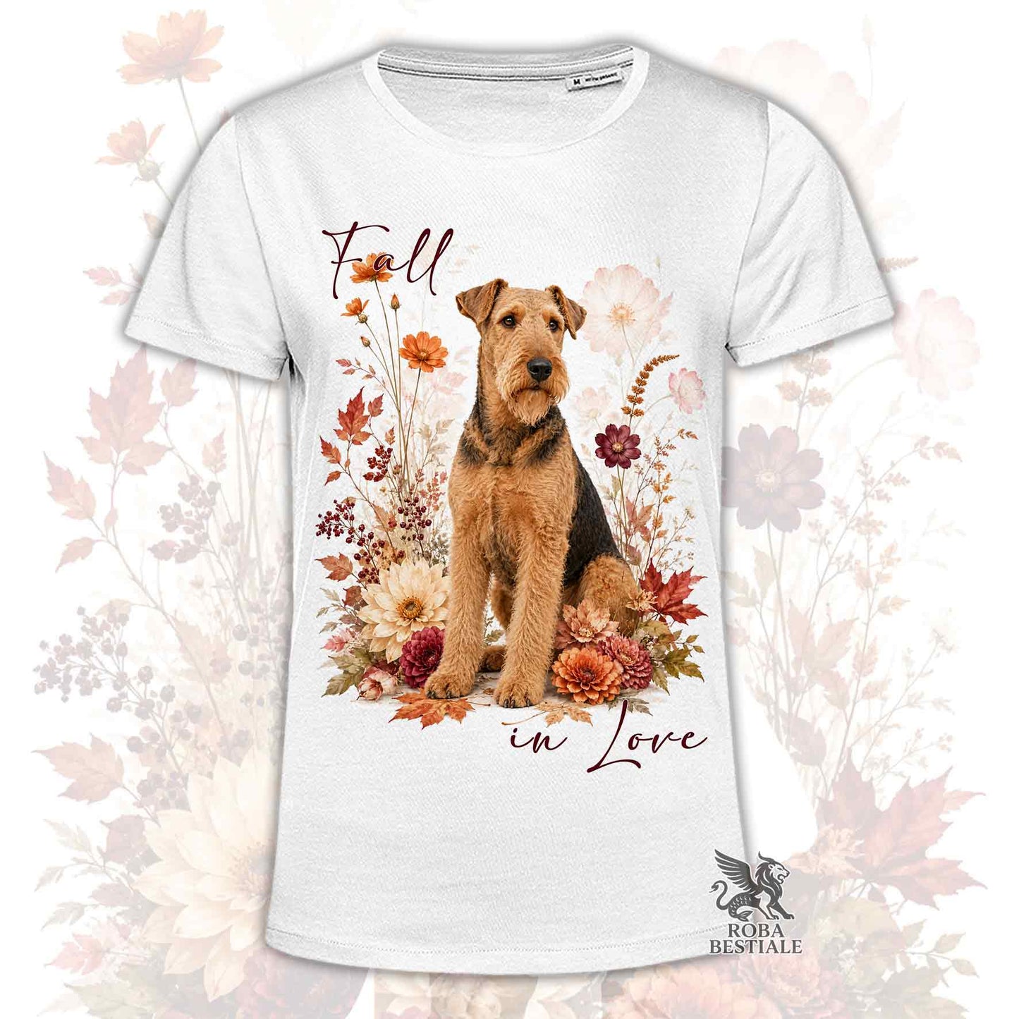 T-shirt bianca stampata con un Airedale Terrier seduto in mezzo a fiori e foglie autunnali. Grafica originale Roba Bestiale, collezione Fall