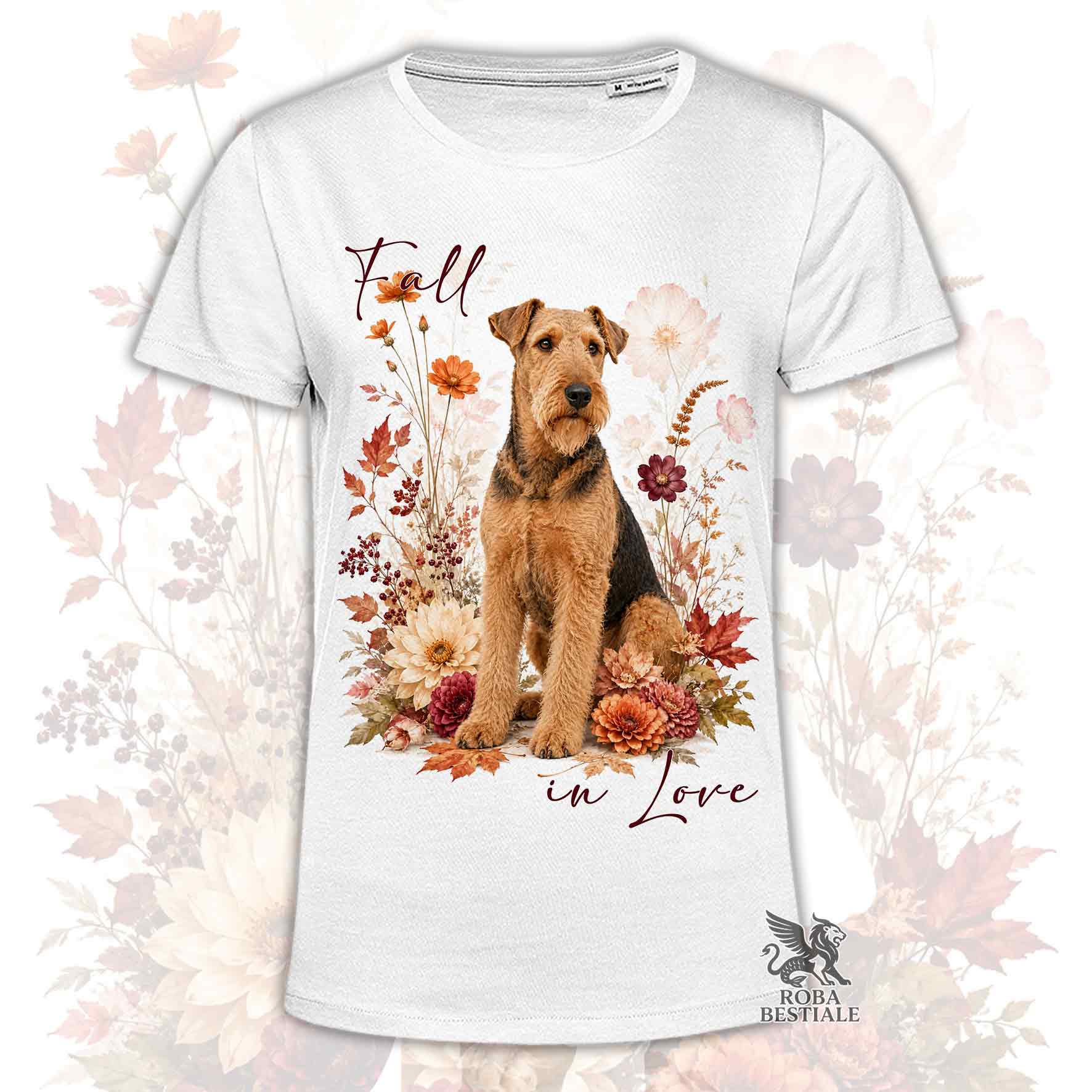 T-shirt bianca stampata con un Airedale Terrier seduto in mezzo a fiori e foglie autunnali. Grafica originale Roba Bestiale, collezione Fall