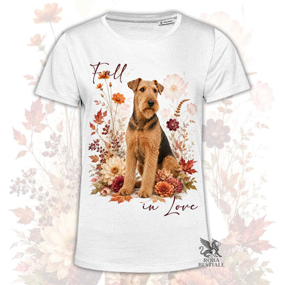 T-shirt bianca stampata con un Airedale Terrier seduto in mezzo a fiori e foglie autunnali. Grafica originale Roba Bestiale, collezione Fall