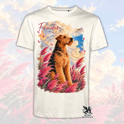 T-shirt color avorio con stampa di un Airedale Terrier tra erbe rosa e la scritta Freedom