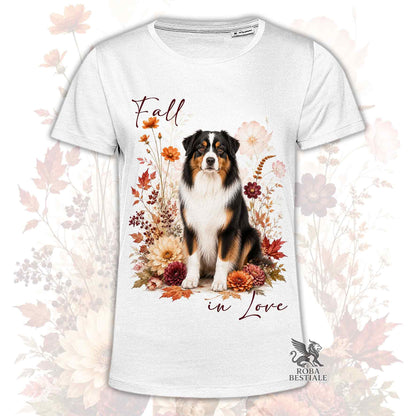 T-shirt bianca stampata con un Australian Shepherd seduto in mezzo a fiori e foglie autunnali. Grafica originale Roba Bestiale, collezione Fall in Love