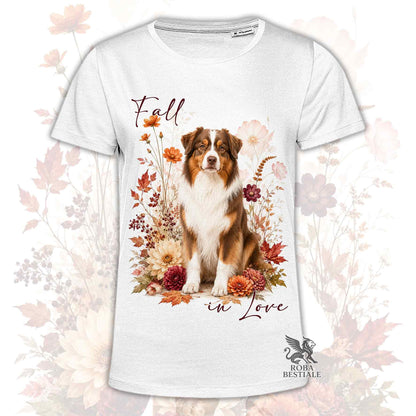 T-shirt bianca stampata con un Australian Shepherd seduto in mezzo a fiori e foglie autunnali. Grafica originale Roba Bestiale, collezione Fall in Love