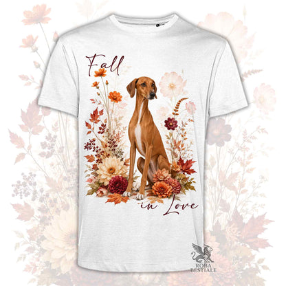 T-shirt bianca stampata con un Azawakh seduto in mezzo a fiori e foglie autunnali. Grafica originale Roba Bestiale, collezione Fall in Love