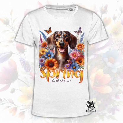Una t-shirt bianca stampata con un Bassotto a pelo corto immerso nei fiori colorati. Collezione Spring Love di Roba Bestiale