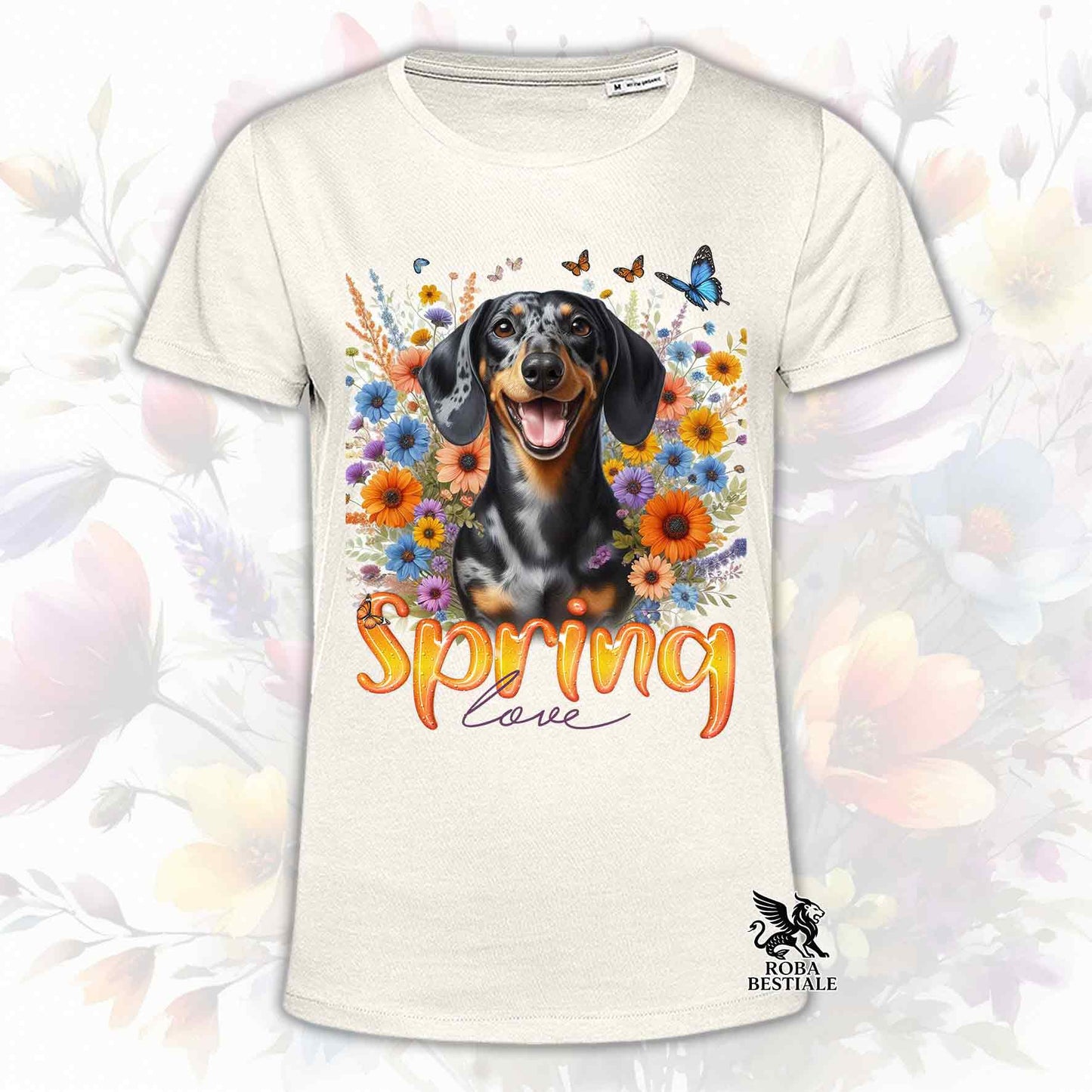 Una t-shirt beige stampata con un Bassotto a pelo corto immerso nei fiori colorati. Collezione Spring Love di Roba Bestiale