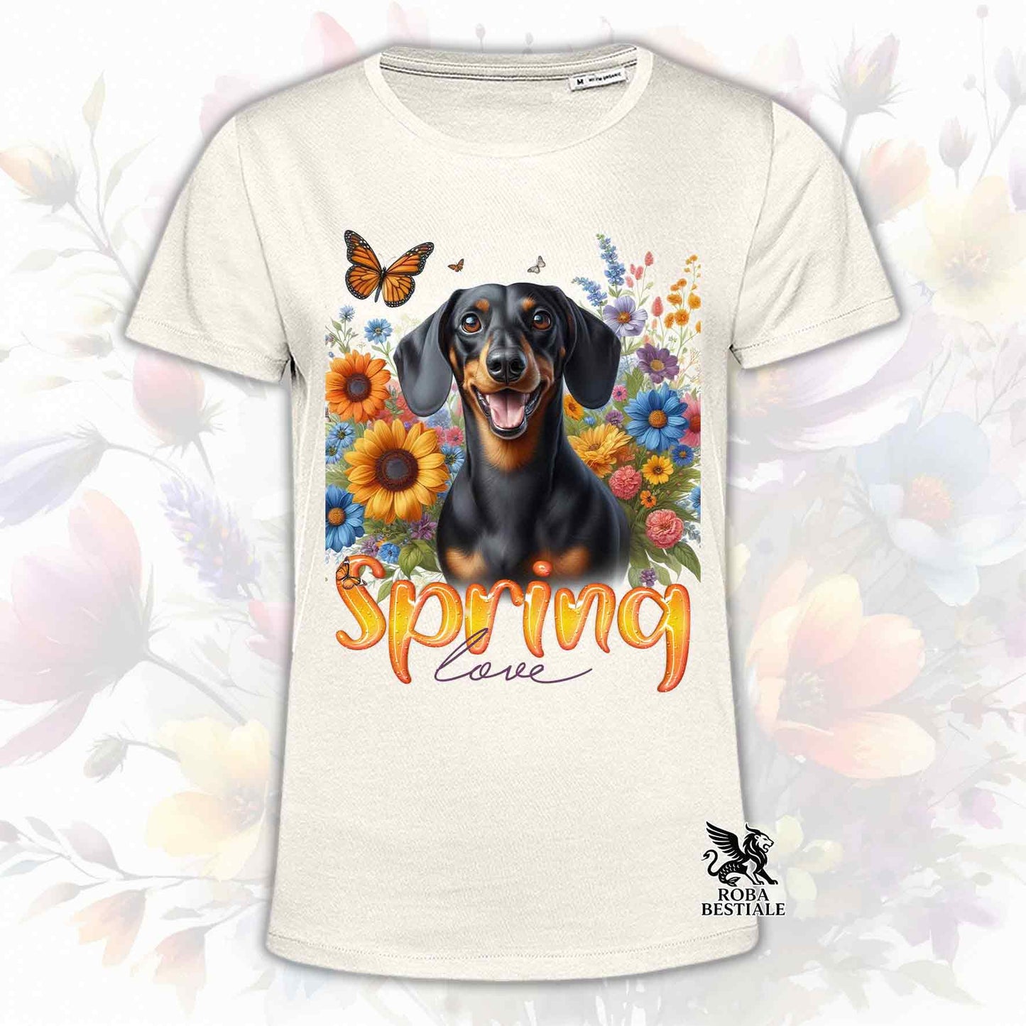 Una t-shirt beige stampata con un Bassotto a pelo corto immerso nei fiori colorati. Collezione Spring Love di Roba Bestiale