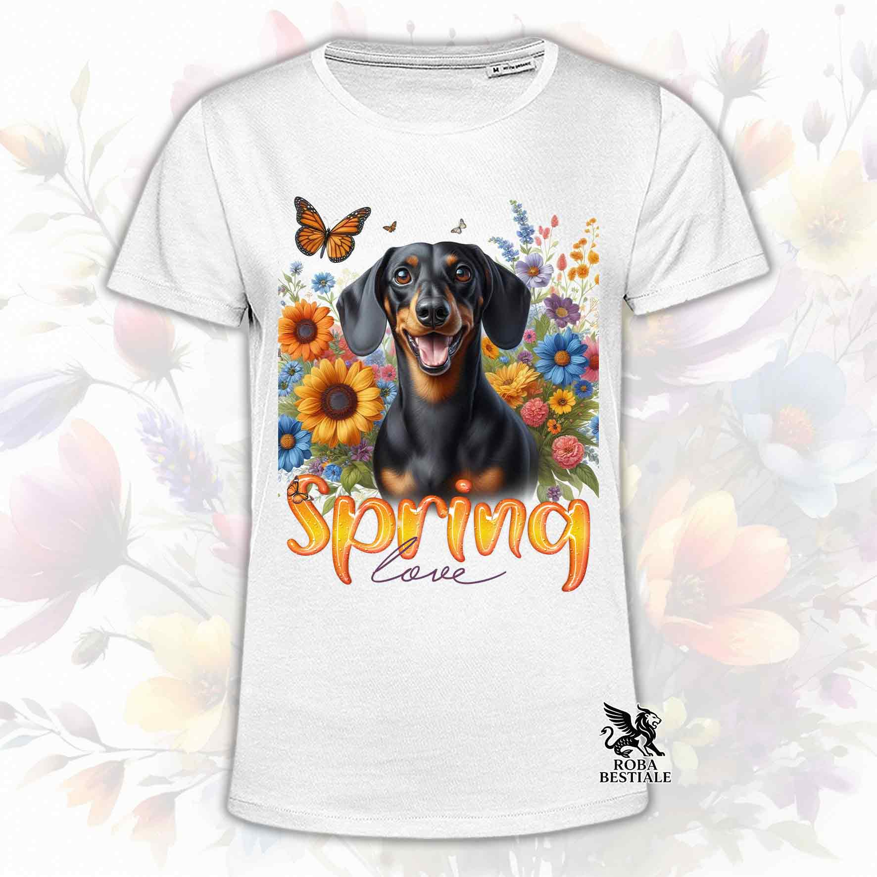 Una t-shirt bianca stampata con un Bassotto a pelo corto immerso nei fiori colorati. Collezione Spring Love di Roba Bestiale