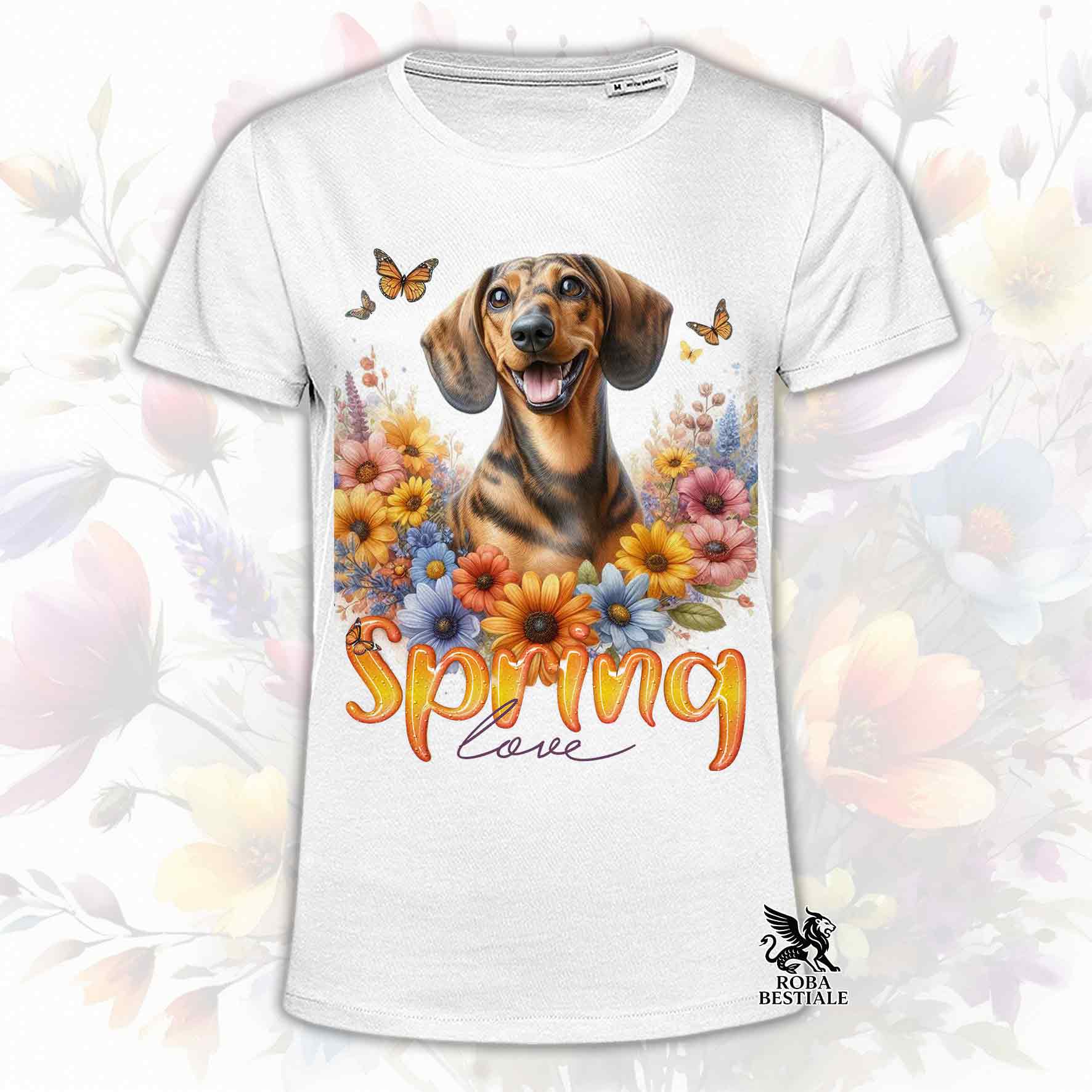 Una t-shirt bianca stampata con un Bassotto a pelo corto immerso nei fiori colorati. Collezione Spring Love di Roba Bestiale