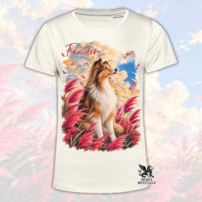 T-shirt bianca con stampa cane tra piume rosa e blu, scritta Freedom, logo in basso