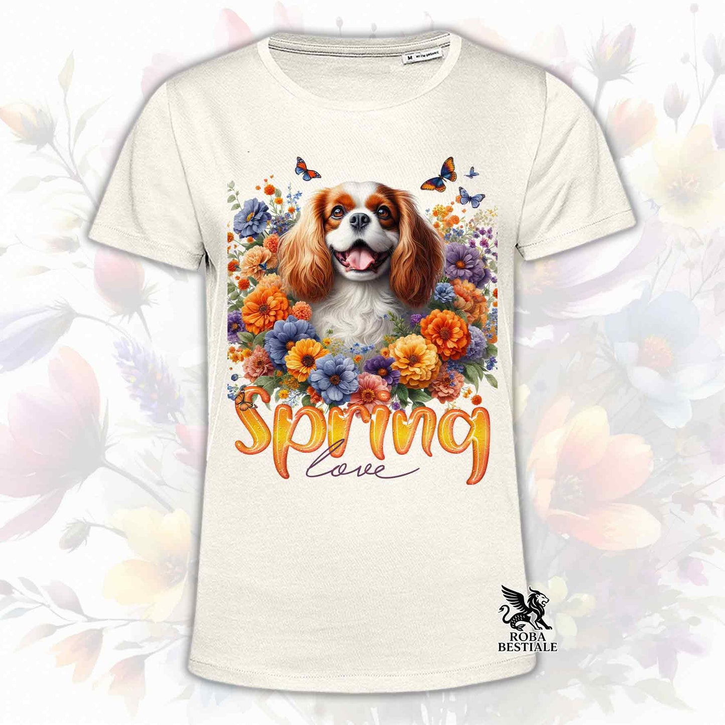 Una t-shirt beige stampata con un Cavalier King Charles Spaniel immerso in fiori colorati. Collezione Spring Love di Roba Bestiale