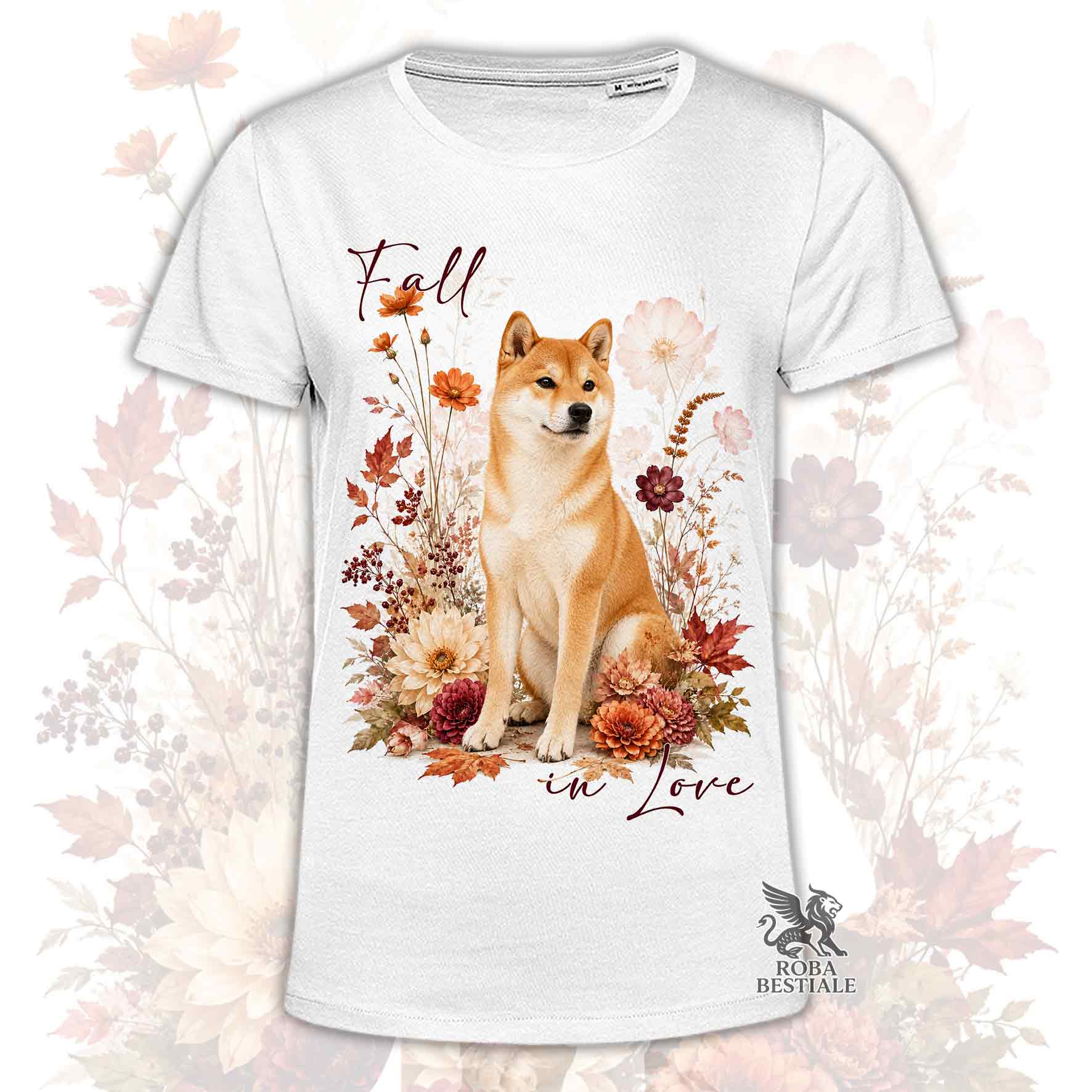 T-shirt bianca stampata con uno Shiba Inu seduto in mezzo a fiori e foglie autunnali. Grafica originale Roba Bestiale, collezione Fall in Love