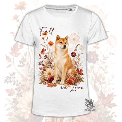 T-shirt bianca stampata con uno Shiba Inu seduto in mezzo a fiori e foglie autunnali. Grafica originale Roba Bestiale, collezione Fall in Love