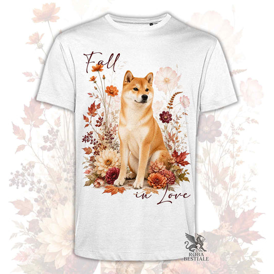 T-shirt bianca stampata con uno Shiba Inu seduto in mezzo a fiori e foglie autunnali. Grafica originale Roba Bestiale, collezione Fall in Love